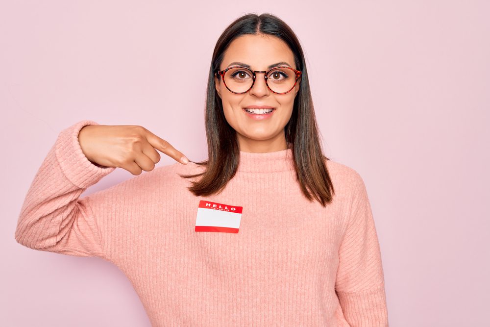 Young woman pointing at a blank name tag